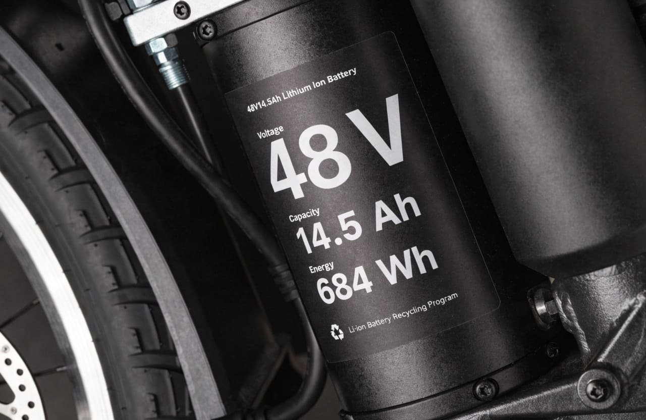 A close-up shot of an e-bike battery label showing Voltage, Ah, and Wh ratings